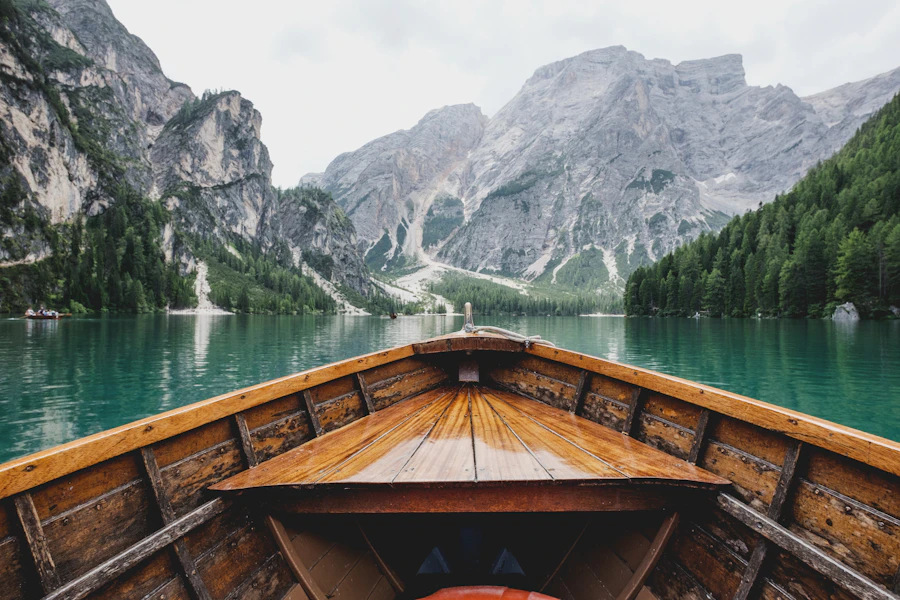 A wooden boat on a still alpine lake surrounded by mountains